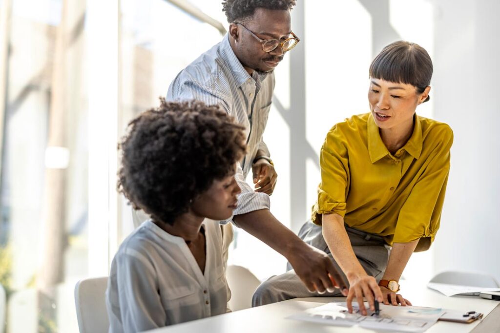 Three colleagues working together to solve a problem