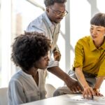 Three colleagues working together to solve a problem