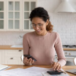 woman work from home makes calculations on calculator