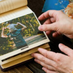 Young woman adding printed photo to family picture album