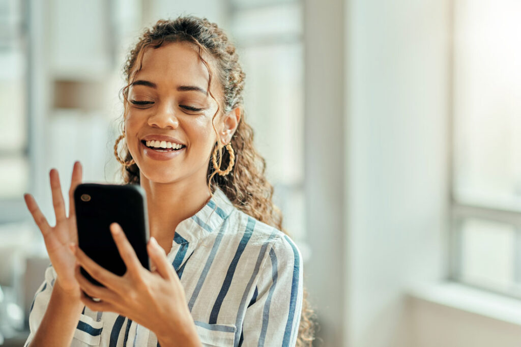 Smiling woman using the Fidelity mobile app on her phone
