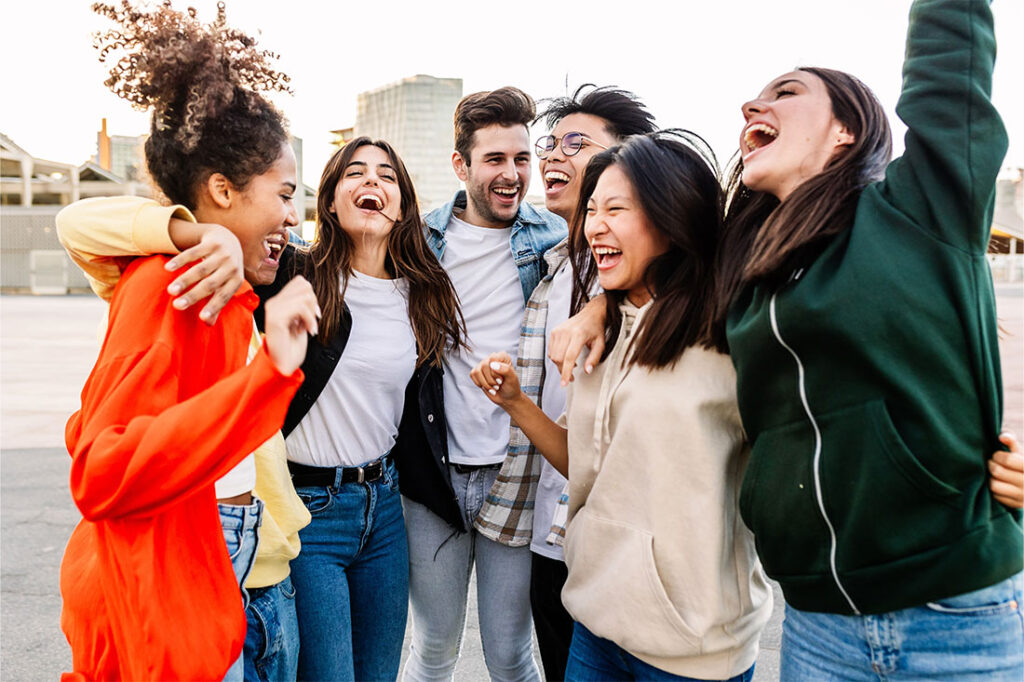 Young group of happy multiracial friends laughing together outdoor