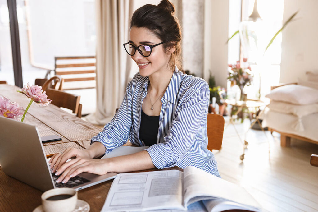 Gen Z woman typing on laptop while working or studying at home