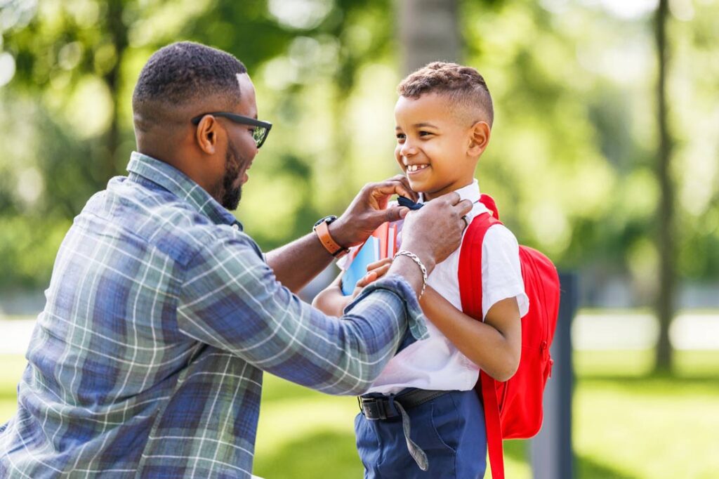 Father helping young son get ready for back to school with products that make it easier