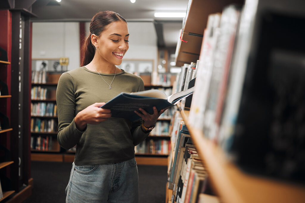 A woman reading a book in a library