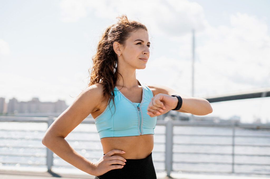 A woman uses a smart watch while exercising