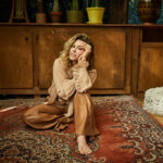 Rachel Platten poses in front of a brown dresser