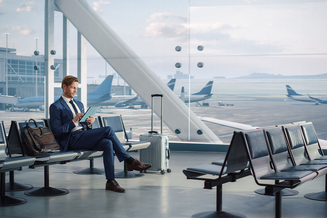 Business man at airport using tablet for business travel