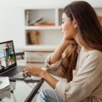 A woman sits at her desk while on a zoom meeting.