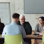 A group of people sit around a conference table.