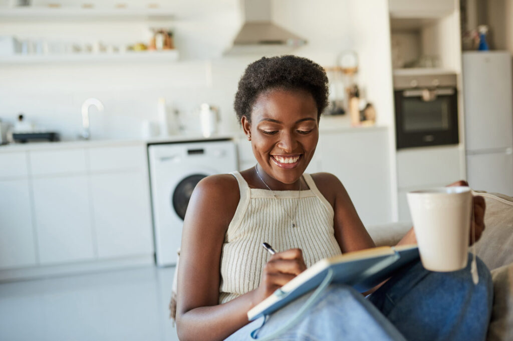 Smiling woman setting success habits in her journal