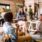 group of co-workers laughing and drinking coffee