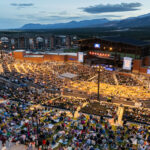 aerial of concert stadium at night and mountain backdrop