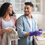 Husband and wife washing and drying dishes together