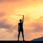 Stand strong. Woman with fist in the air. Feeling motivated, strength and courage concept.
